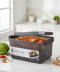 Kimchi stored in a black Lock and Lock container with Korean labeling in a white and modern kitchen