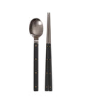 Spoon and chopsticks with black handles on a white background