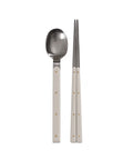Stainless steel spoon and chopsticks with gray handles on a white background