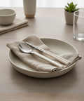 Ceramic plate with cutlery and folded napkin on a wooden table