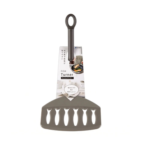 A gray silicone fish turner spatula with a black handle, shown with its retail packaging card against a plain white background.