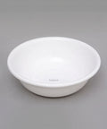 A white ceramic bowl with a small 'bianca' brand mark printed inside, set against a solid gray background.
