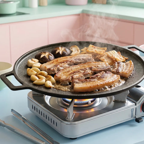 Grill pan with meat and vegetables on a portable stove in a kitchen setting