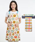 Woman wearing a colorful apron with a donut pattern, next to a folded plaid towel on a white background.