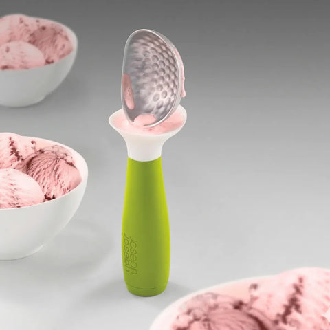 Green ice cream scoop with pink ice cream on a gray background