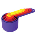 Set of colorful measuring cups stacked on a white background