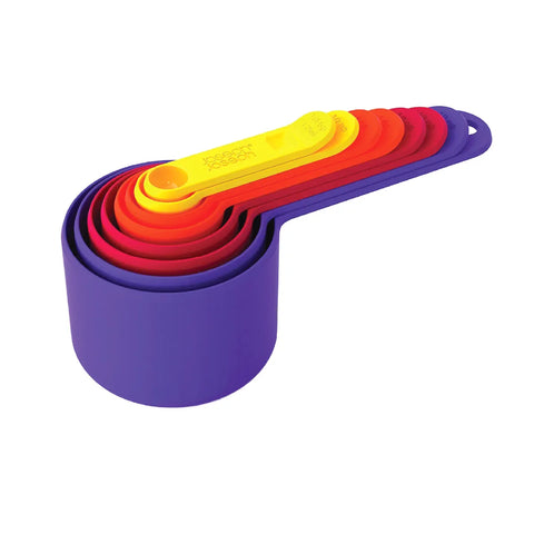 Set of colorful measuring cups stacked on a white background