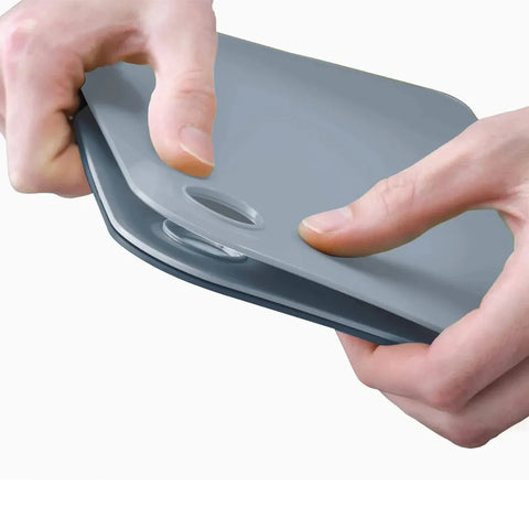Blue and gray cutting boards held by a hand on a white background