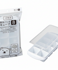 An 8-compartment ice cube tray shown both inside its clear plastic packaging and unpackaged on a white background. The packaging features Japanese text and a cartoon polar bear illustration.