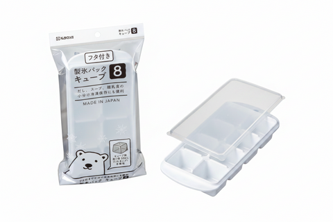 An 8-compartment ice cube tray shown both inside its clear plastic packaging and unpackaged on a white background. The packaging features Japanese text and a cartoon polar bear illustration.