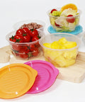 Assorted containers with fruits, vegetables, and snacks on a white background