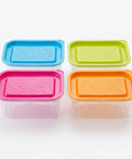 Four colorful plastic containers with lids on a white background