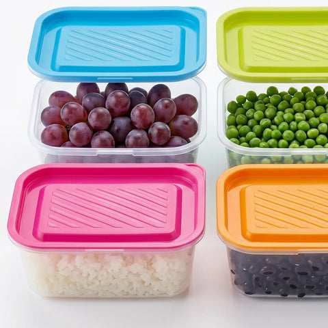 Set of colorful food storage containers with lids containing grapes, peas, rice, and black beans.