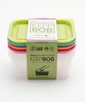 Stack of Keep Bob food containers with green lids on a white background