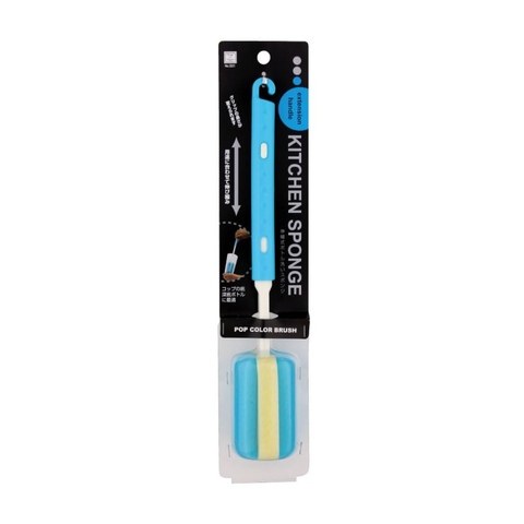 A kitchen sponge brush in its retail packaging, featuring a light blue handle and a dual-sided sponge head with blue and pale yellow sections. The product is mounted on a black cardboard backing card labeled 'KITCHEN SPONGE' with a blue 'POP COLOR BRUSH' badge.