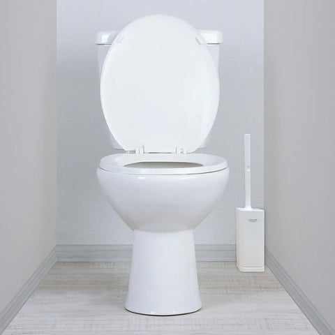 A white ceramic toilet with the lid open, shown in a clean bathroom setting with a matching white toilet brush holder on the right.