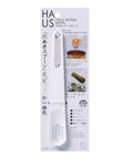 HAUS Hole Spoon & Pick kitchen utensil in its original white and silver blister packaging, featuring a white plastic spoon with a silver metal handle.