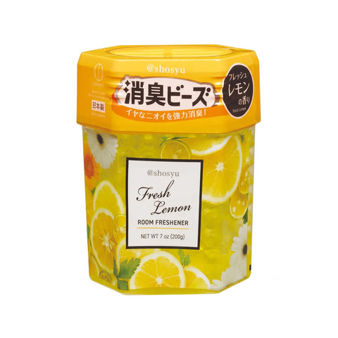 A hexagonal container of Shosyu Fresh Lemon room freshener, featuring a bright yellow lid and a clear lower section filled with yellow liquid and printed lemon and daisy illustrations.