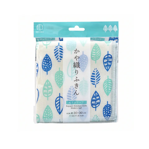 A packaged kitchen cloth with a white background and a repeating leaf pattern in blue, teal, and light green. The package has a teal header card with a hanging tab and Japanese text on the front.