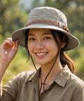 Woman wearing a wide-brimmed hat outdoors with a blurred natural background