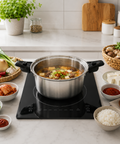 Stovetop with a pot of soup on a kitchen counter with ingredients around