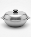 A stainless steel wok with a matching lid and side handles, photographed on a clean white background.