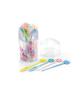 A set of pastel flower-shaped hair picks displayed with their clear cylindrical holder and a small clear geometric box on a white background.