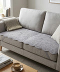 Gray sofa with a textured gray couch pad in a living room setting.