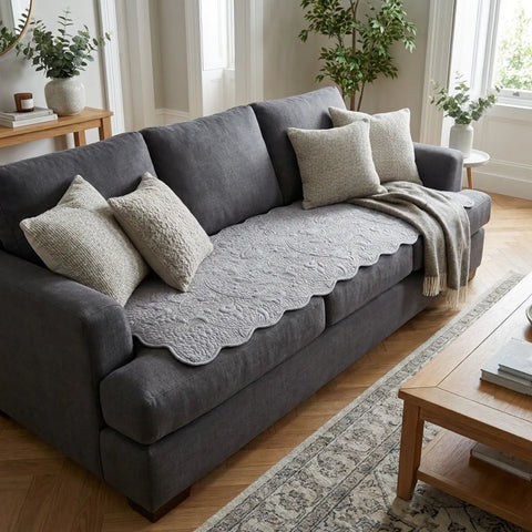 Gray sofa with decorative pillows and gray couch pad in a living room setting.