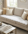Beige sofa with white couch pad and decorative pillows in a living room setting