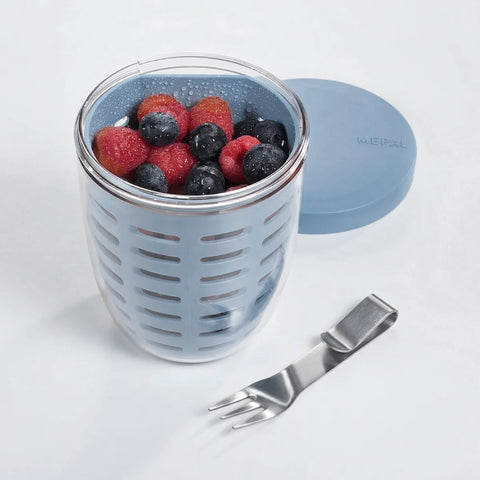 Container with berries, blue lid, and fork on a white background