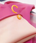 Pink fabric with a yellow hanger on a blurred background