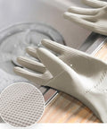 Beige cleaning gloves with textured surface on a kitchen counter.