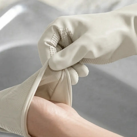 Close-up of hands wearing beige rubber gloves against a neutral background