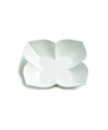 A white ceramic four-petal flower-shaped dish, photographed from a top-down angle on a clean white background.