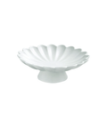 A white ceramic pedestal dish with a scalloped, shell-like rim, shown against a plain white background.