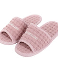 Pair of pink slippers with 'Cotton House' branding on a white background