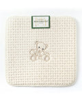 Woven mat with a teddy bear design and a brand label on a white background