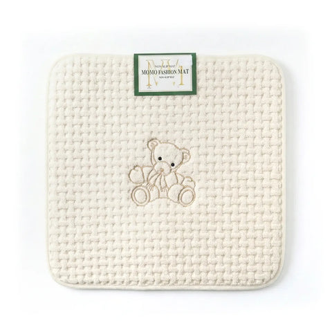 Woven mat with a teddy bear design and a brand label on a white background