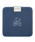 Blue textured mat with a teddy bear design and a brand label on a white background