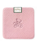 Pink textured mat with an embroidered teddy bear design on a white background