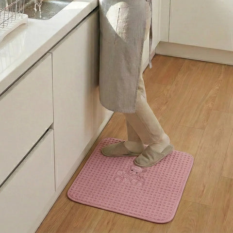 Person standing on a pink bath mat in a kitchen
