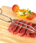 Stainless steel triangle tongs gripping cuts of raw beef on a wooden cutting board.