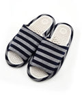 A pair of open-toe slide sandals with navy blue and gray horizontal stripes on the straps, featuring white contoured footbeds with raised massage nodules, shown on a white background.