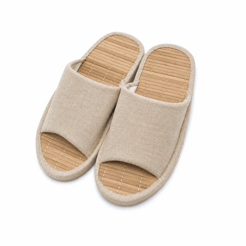 A pair of open-toe slip-on slippers with beige woven fabric uppers and natural bamboo-look footbeds, shown on a plain white background.