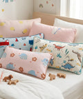 Set of colorful children's pillows on a bed with toys around