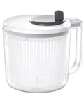 Clear plastic salad spinner with white lid and black handle on a white background