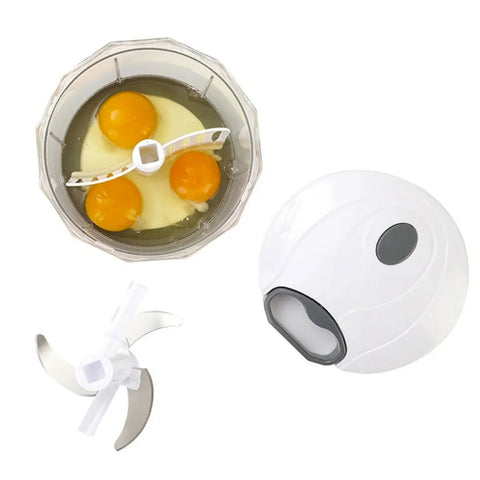 Small blender with eggs inside and a white handheld blender on a white background
