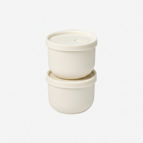 Two white silicone containers with lids on a white background
