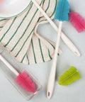Cleaning tools including brushes and a cloth on a light surface
